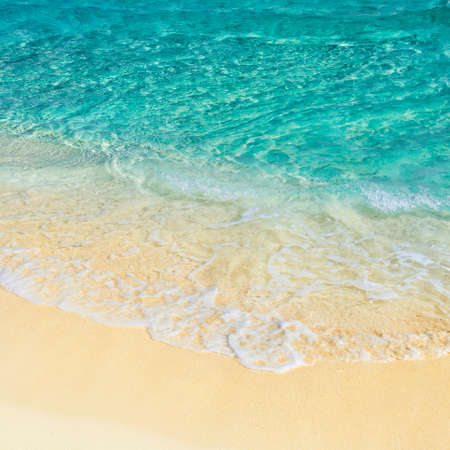 Soft wave of the turquoise sea on the sandy beach. Natural summer background with copy space. Playa...