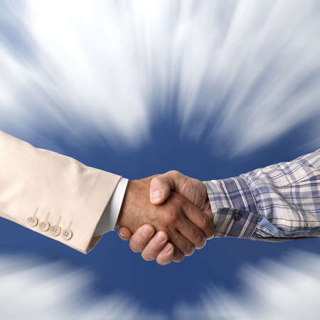 Handshake against the blue skyの写真素材