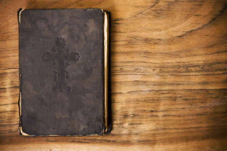 The old, wise book lies on a wooden backgroundの写真素材