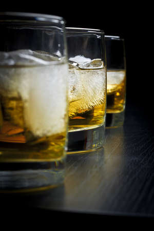 Whisky with ice in glasses on a black backgroundの写真素材
