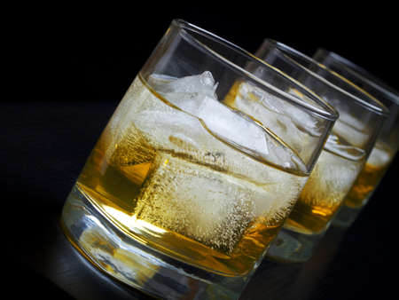 Whisky with ice in glasses on a black backgroundの写真素材