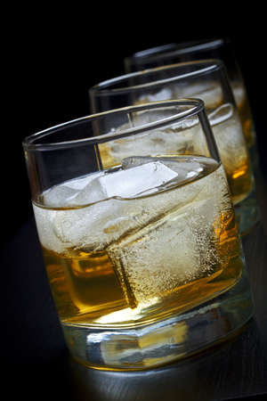 Whisky with ice in glasses on a black backgroundの写真素材