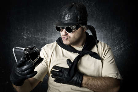 The man and the old camera against a dark backgroundの写真素材