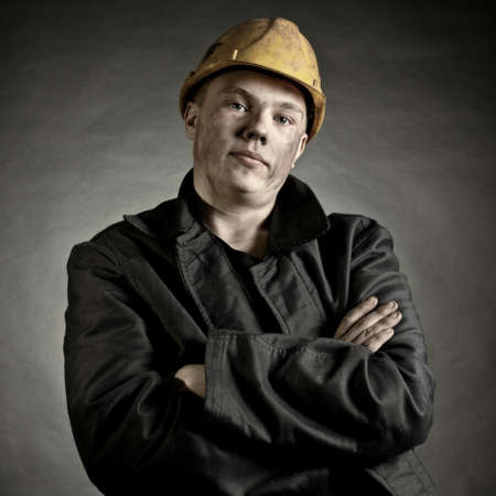 Portrait of the young worker against a dark backgrounの写真素材