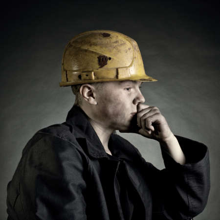 Portrait of the young worker against a dark backgrounの写真素材