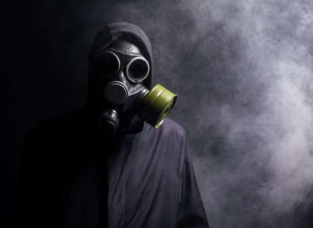 A man in a gas mask in the smoke. black backgroundの写真素材