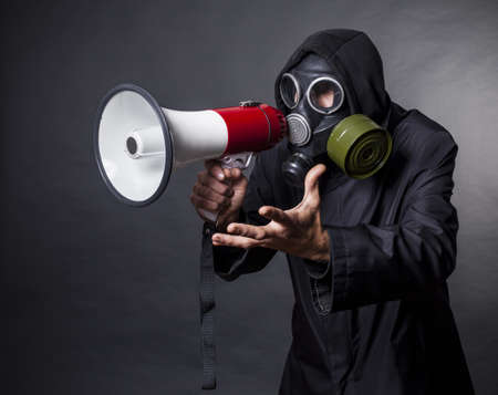 a man in a gas mask with a megaphone calling for help