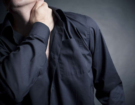 Pain neck. Male on a black backgroundの写真素材