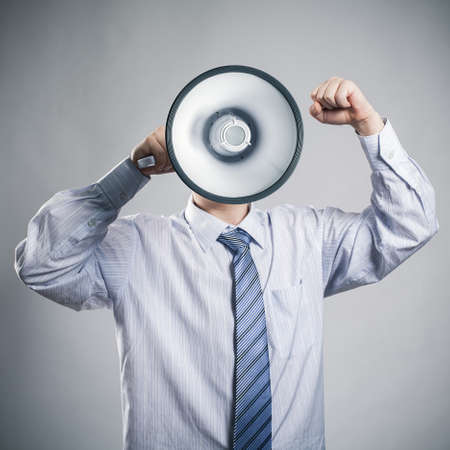 Businessman shouting into a megaphoneの写真素材