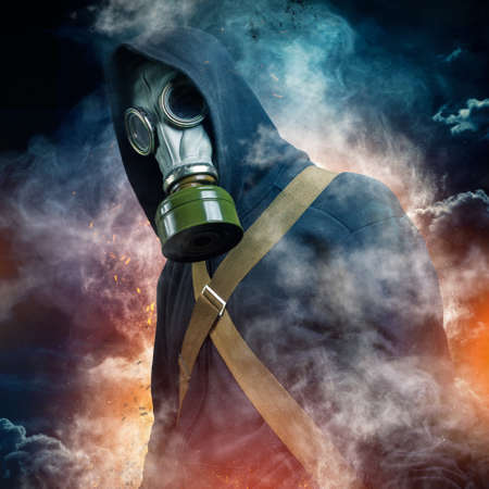 A man in a gas mask shrouded in smoke