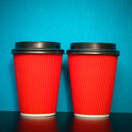two plastic cups of red on a turquoise backgroundの写真素材