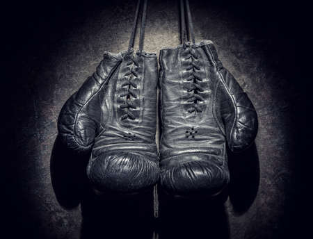 old boxing gloves on a dark backgroundの写真素材