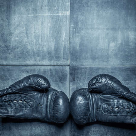 Old boxing gloves on wooden background