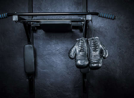 Old boxing gloves on a dark background.
