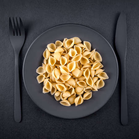 Shell pasta on a plate. Black backgroundの写真素材