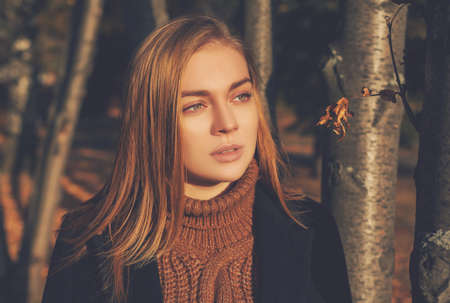 Portrait of a young woman on an autumn background