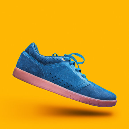 Blue sneakers on a yellow background.の写真素材