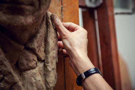 Woman sculptor at work. Sculptor's hand close up.の写真素材