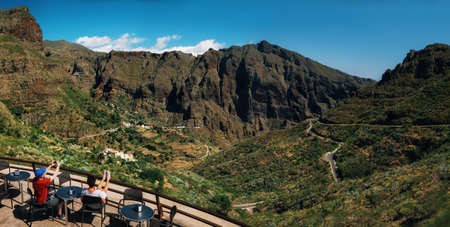 Masca, Tenerife, Canary islands, Spain - May 25, 2017: Panoramic view of Masca valley. Tourists are in cafe on mountain pass and admire Scenic mountain landscape.のeditorial素材