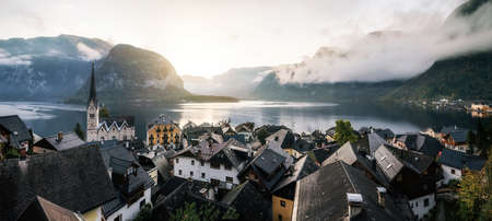 Panoramic scenic view of famous Hallstatt town reflecting in Austrian Alps in morning light in autumn at sunrise, Salzkammergut region, Austriaの写真素材