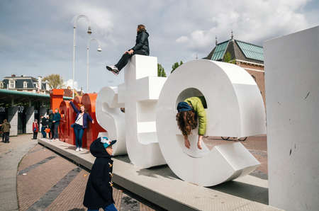 Amsterdam, Netherlands - April 27,2017: Diversity tourists interact with huge letters I Amsterdam - symbol of city.のeditorial素材