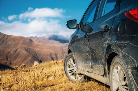 Off-road travel on car on mountain road against rocks in Caucasus, Georgia. Beautiful lights and colors at sunsetの写真素材