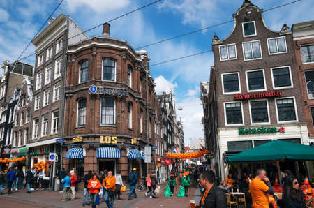 Amsterdam, Netherlands - 27 April, 2017: Streets of Amsterdam with orange decorations full of people in orange during the celebration of kings day.のeditorial素材