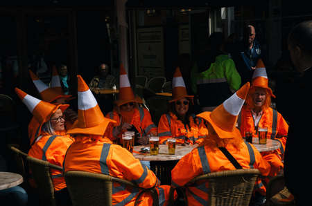 Amsterdam, Netherlands - 27 April, 2017: Group of people wearing orange costumes with hat like traffic cone on Day of the King in Amsterdamのeditorial素材