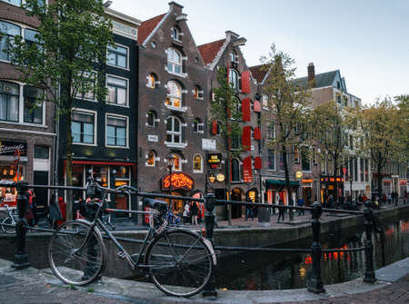 Amsterdam, Netherlands - May 25, 2016: Outside view of Red Light District with bridge, bicycle and...