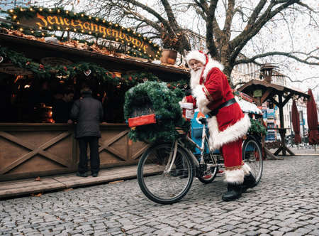 Munich, Bavaria, Germany - December 6, 2017: Santa Claus drives a decorated bicycle with gifts on Christmas Market Rindermarkt in Munich.のeditorial素材