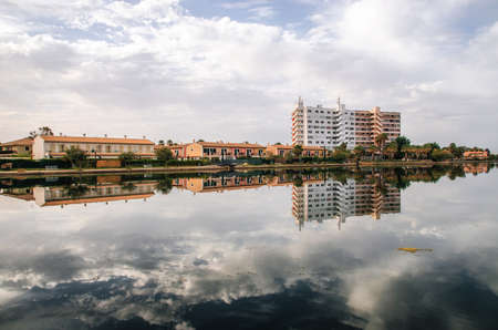 Alcudia, Mallorca, Spain - May 25, 2015: Multi-storey hotel is reflected in the Esperanza lake in Port d'Alcudia. Beautiful reflection of the sky and cloudsのeditorial素材