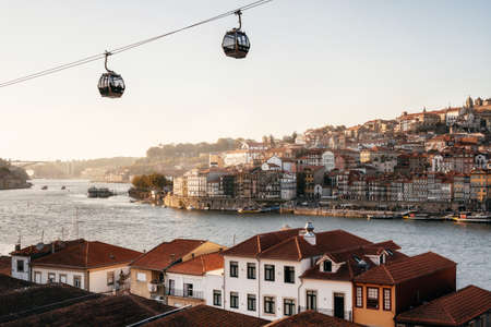 Old town of Porto on Douro River with cable cars and boats at sunset, Portugal.の写真素材