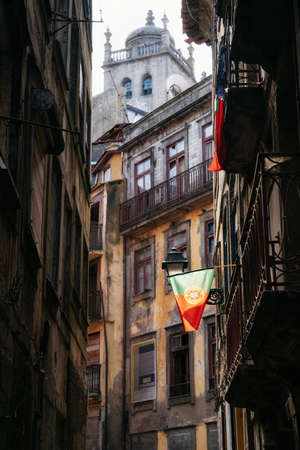 Portuguese flag on narrow cobblestone street leading to Cathedral Se in Porto, Portugalの写真素材