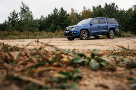 Minsk, Belarus - September 20, 2019: Volkswagen Amarok 4x4 pickup truck on country road at woodland.