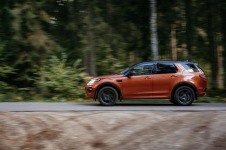 Minsk, Belarus - September 24, 2019: borwn color car Land Rover Discovery Sport fast moving on...