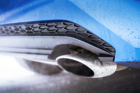 Combustion fumes coming out of car exhaust pipe of blue modern carの写真素材
