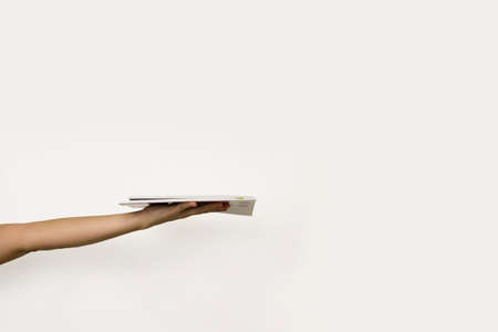 female hand holds a stack of books on a white background