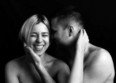 Man and woman, close-up portrait, hands near face, love, laughter, dark background