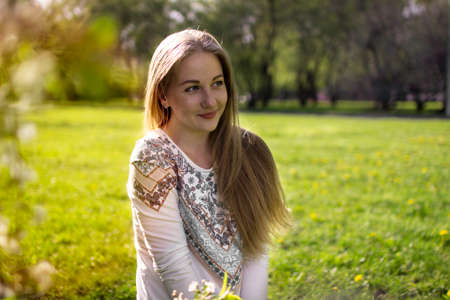 portrait of a young blonde woman in a spring forest and in sunlightの写真素材