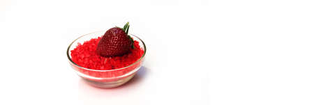Glass bowl of red salt on white with strawberryの写真素材