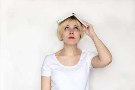 Beautiful of portrait young woman holding book, girl tired and bored reading book studying for exams, education and lifestyle concept.の写真素材