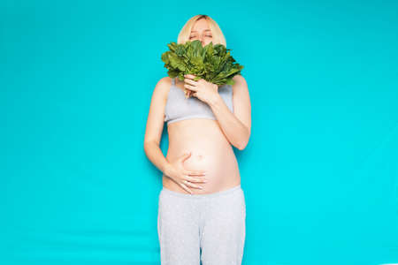 Woman in pregnant eating healthy vegetables salad ??? spinachの写真素材