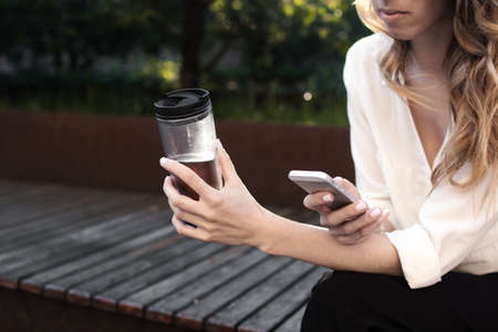 Young attractive woman at the street, browising in internet drinking coffee, Business concept photo