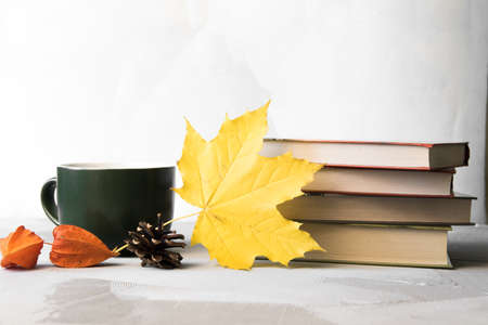 Autumn concept stack of books, coffe cup and maple leavesの写真素材