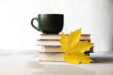Autumn concept stack of books, coffe cup and maple leavesの写真素材