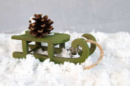 christmas green sled carry pine cone, light star garland, vintage style, new year night composition