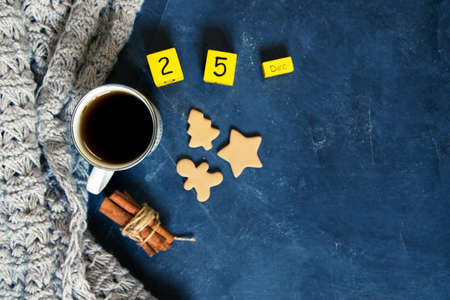 Winter composition. Cup of coffee, cookie, lights on a dark background. Flat layの写真素材