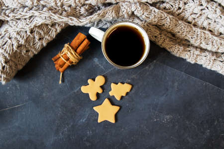 Winter composition. Cup of coffee, cookie, lights on a dark background. Flat layの写真素材