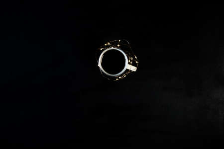 One cup with coffee on black table with christmas lights. Photograph taken from above, top view with copy space.の写真素材