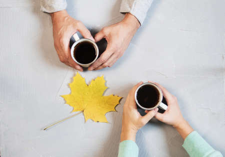 Couple in love holding hands with coffee on white marble table. Photograph taken from above, top view with copy space. maple leafの写真素材